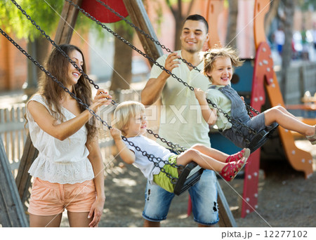Daughters on swings with parents Daughters on swings with parents 12277102