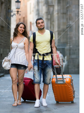 Man and woman in shorts walking through city Man and woman in shorts walking through city 12277107