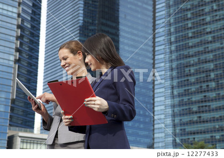 Businesswomen looking at tablet outside Businesswomen looking at tablet outside 12277433