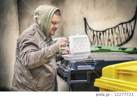 Homeless near yellow garbage container  Homeless near yellow garbage container  12277723