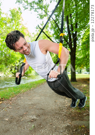 man doing suspension trainer sling sport 12278173