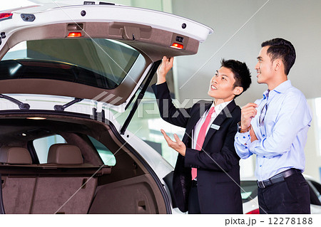 Asian man looking at car in dealership Asian man looking at car in dealership 12278188