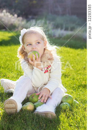 Child with green apples sitting on grass 12283385