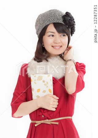 一冊の本を大切そうに抱えるミドルの女性 12287351