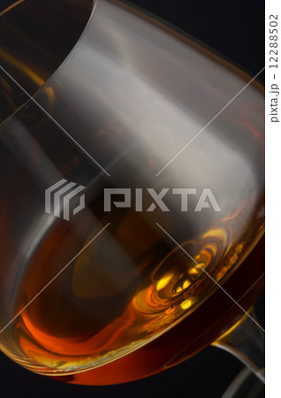 Glass of brandy over black background Glass of brandy over black background 12288502