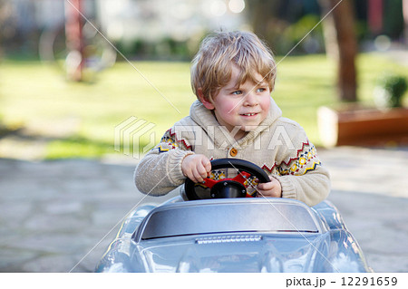 Little boy driving big toy car, outdoors Little boy driving big toy car, outdoors 12291659