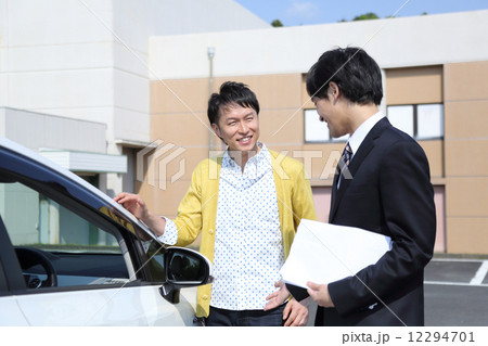 車の説明をする営業マン 12294701
