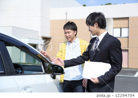 車の説明をする営業マンの写真素材