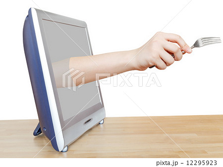 fork in female hand leans out TV screen 12295923