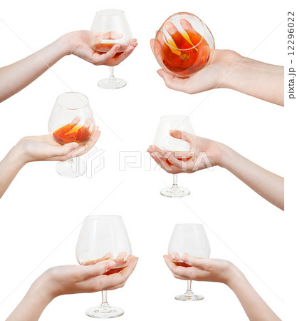 set of hand holds glass goblet with cognac 12296022