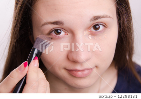 Makeup artist brush smears concealer on the eyelids model Makeup artist brush smears concealer on the eyelids model 12298131
