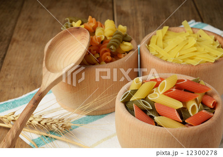 Raw tricolor pasta set on the wooden table Raw tricolor pasta set on the wooden table 12300278