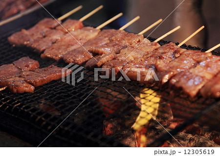 たくさん並べた牛串の網焼き 12305619