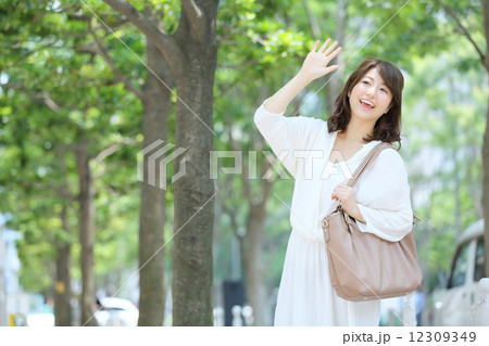 手を挙げる若い女性 12309349