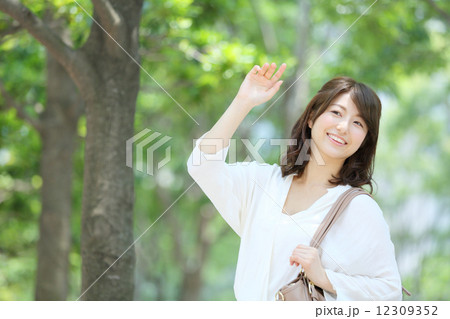 手を挙げる若い女性 12309352