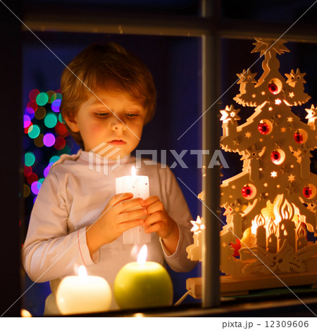 Little boy standing by window at Christmas time 12309606