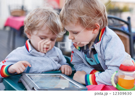 Two little sibling boys having fun together with tablet pc. Two little sibling boys having fun together with tablet pc. 12309630