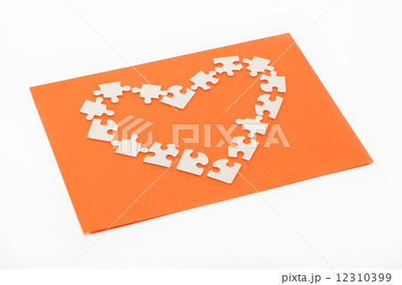 Puzzles in the shape of a heart on an orange background. Puzzles in the shape of a heart on an orange background. 12310399