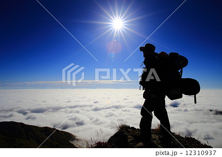 雲海と登山者のシルエットの写真素材