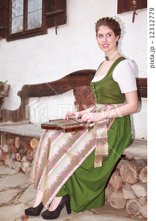 Young Bavarian girl playing the zither on a bank 12312779