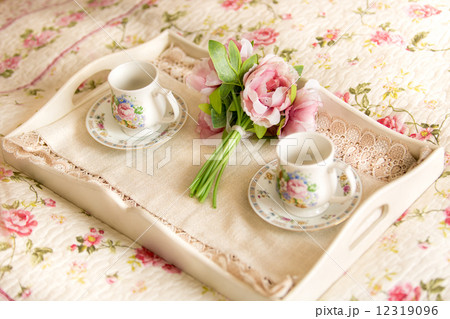 vintage tray with flowers and teacups lying on bed vintage tray with flowers and teacups lying on bed 12319096