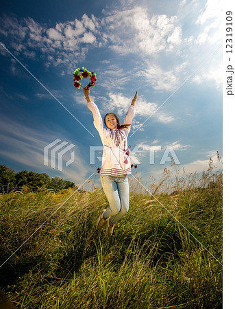 woman in ukrainian national clothes jumping high at field woman in ukrainian national clothes jumping high at field 12319109