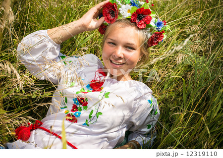 smiling ukrainian girl in national clothes lying on field smiling ukrainian girl in national clothes lying on field 12319110