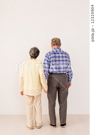 手をつなぐシニアカップルの後ろ姿の写真素材