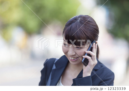 スマートフォンで会話する笑顔の若いビジネスウーマン　986 12323339