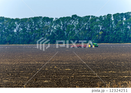 Tractor plowing the land Tractor plowing the land 12324251