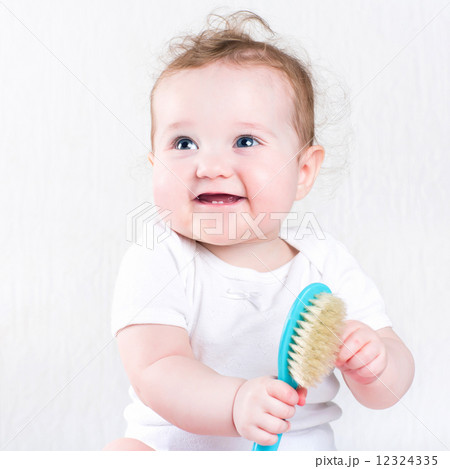 Pretty baby girl playing with a hair brush Pretty baby girl playing with a hair brush 12324335