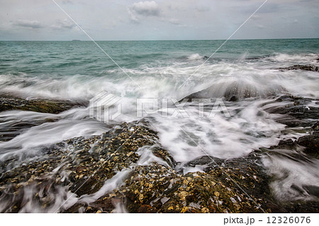 Sea waves crashing to rocks creating foam 12326076