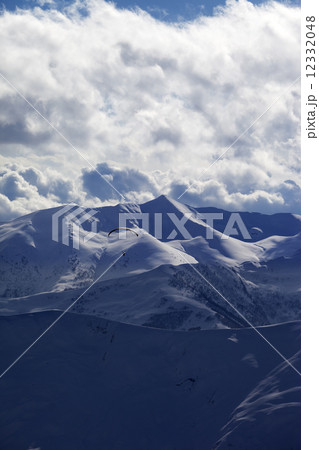 Evening sunlight mountain with clouds and silhouette of paraglid Evening sunlight mountain with clouds and silhouette of paraglid 12332048