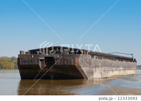 Big black cargo barge is anchored on the Danube river Big black cargo barge is anchored on the Danube river 12333093