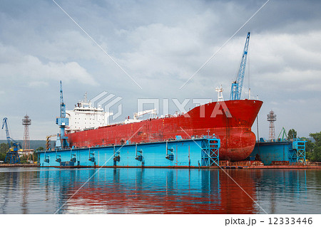 Big red tanker under repairing in blue floating dock Big red tanker under repairing in blue floating dock 12333446