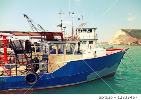 Industrial small fishing boats are moored in port. Vintage toned Industrial small fishing boats are moored in port. Vintage toned 12333467