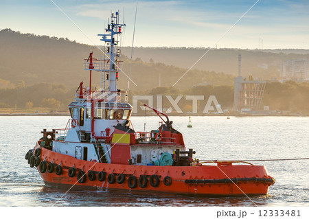 Red tug is underway on Black sea, Varna harbor, Bulgaria Red tug is underway on Black sea, Varna harbor, Bulgaria 12333481