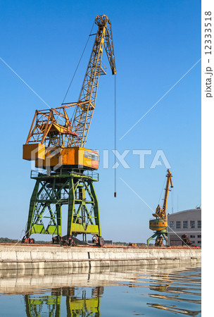 Big industrial harbor cranes works on the river coast Big industrial harbor cranes works on the river coast 12333518