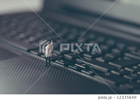 Miniature businessman waving on top of the laptop. Business concept Miniature businessman waving on top of the laptop. Business concept 12335640