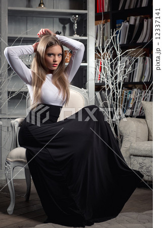 Elegant young woman in long dress posing in luxury vintage interior 12337141