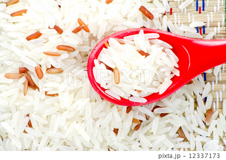 Grain rice in a red color spoon Grain rice in a red color spoon 12337173