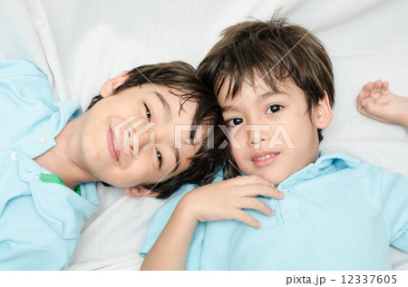 Little sibling boy laying down on the bed 12337605