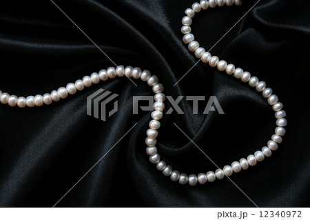 White pearls on the black silk 12340972