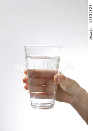 コップの水を持つ女性にの手の写真素材