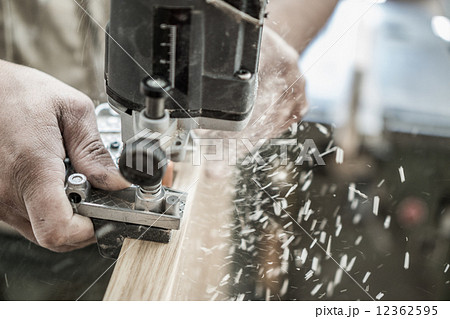 Blurred motion of carpenter working, preparing door for hinges 12362595