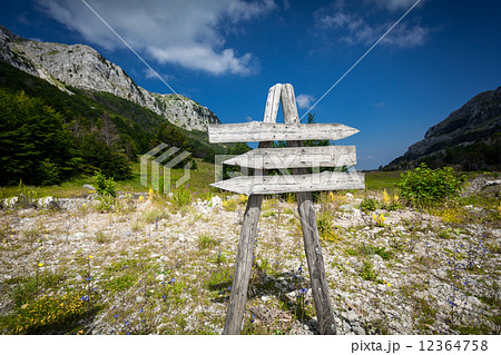 signpost with three directions on the foot of big mountain signpost with three directions on the foot of big mountain 12364758