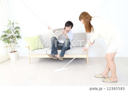 掃除をする女性と新聞を読む男性 掃除をする女性と新聞を読む男性 12365583