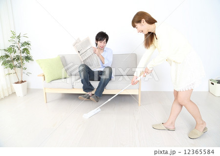 掃除をする女性と新聞を読む男性 掃除をする女性と新聞を読む男性 12365584