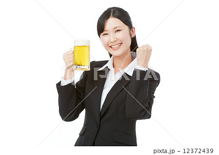 ビールジョッキを持ってガッツポーズするビジネスウーマンの写真素材