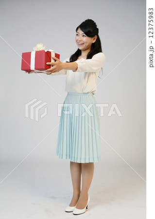 プレゼントを渡す若い女性 12375983